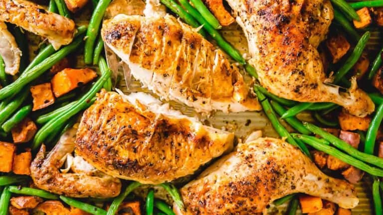 Chicken and sweet potatoes on a baking sheet.