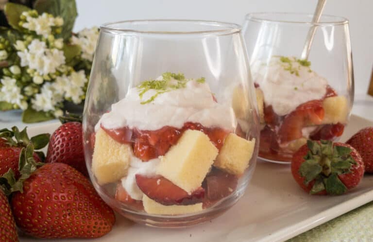 Strawberries, cake and whipped cream layered in dessert glasses.