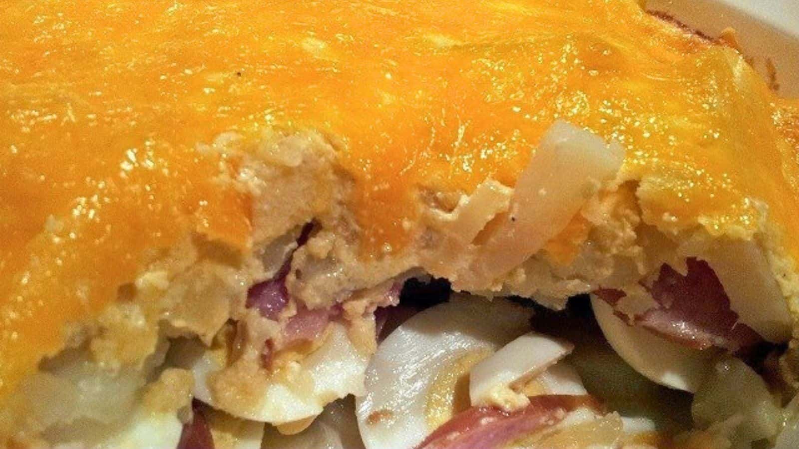 Image shows a close up of a casserole that uses Easter leftovers with hard boiled eggs and cheese and meat.