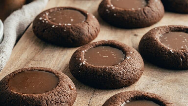 Chocolate salted caramel cookies on a wooden cutting board.