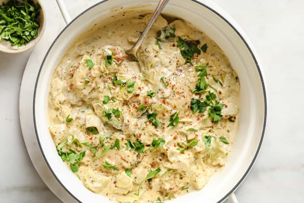 Creamy chicken dish with herbs and spices in a pot, ready to be served.