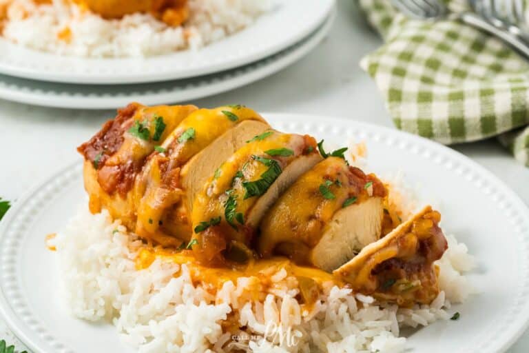 Chicken enchiladas on a plate with rice and sauce.