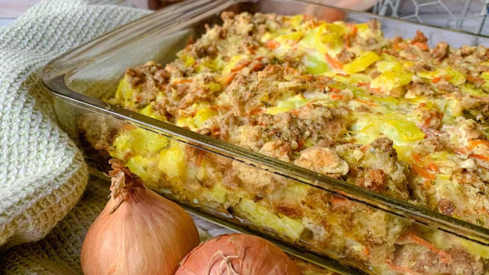 A glass baking dish filled with baked squash casserole.
