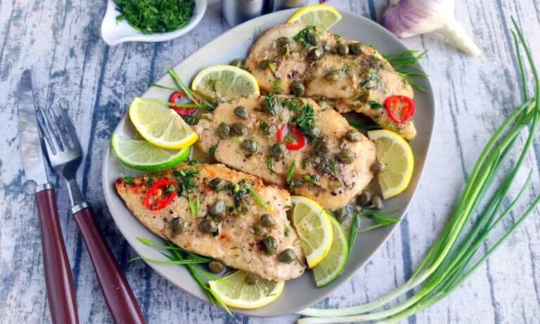 Chicken breasts with lemon and capers on a plate.