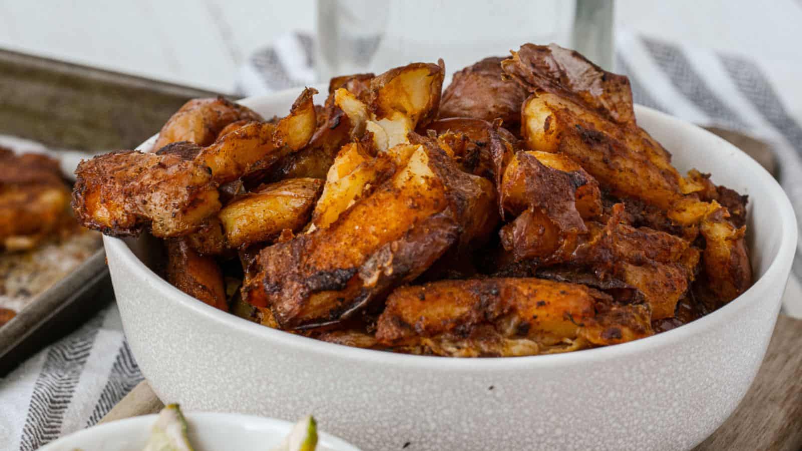 Smashed Red Skin Potatoes in a white bowl.