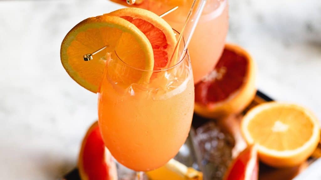A refreshing citrus cocktail garnished with a slice of orange, served in a tall glass among 13 cool drinks.