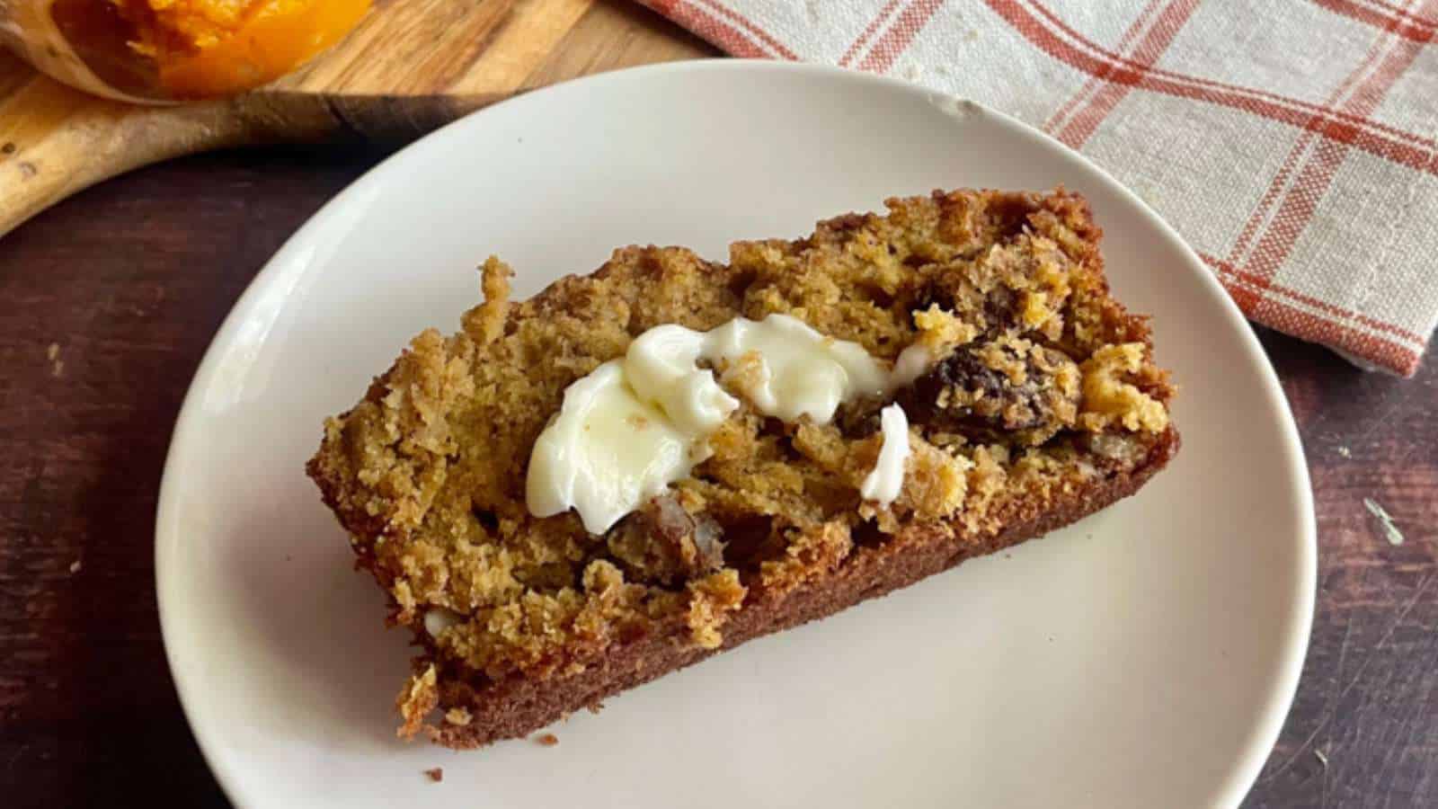 A slice of pumpkin banana bread on a white plate.