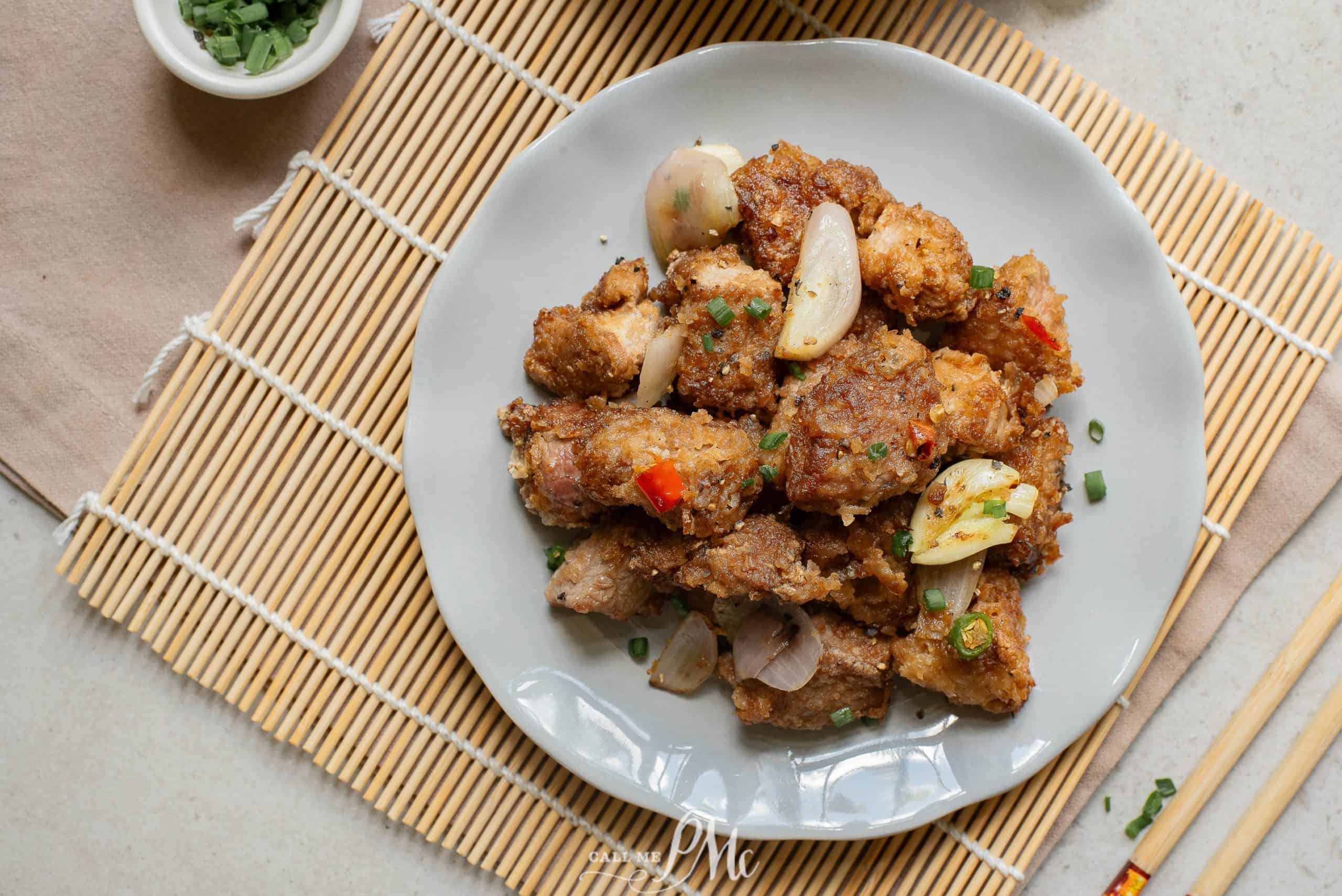 A plate of Salt Pepper Pork Chop Bites on a bamboo mat.