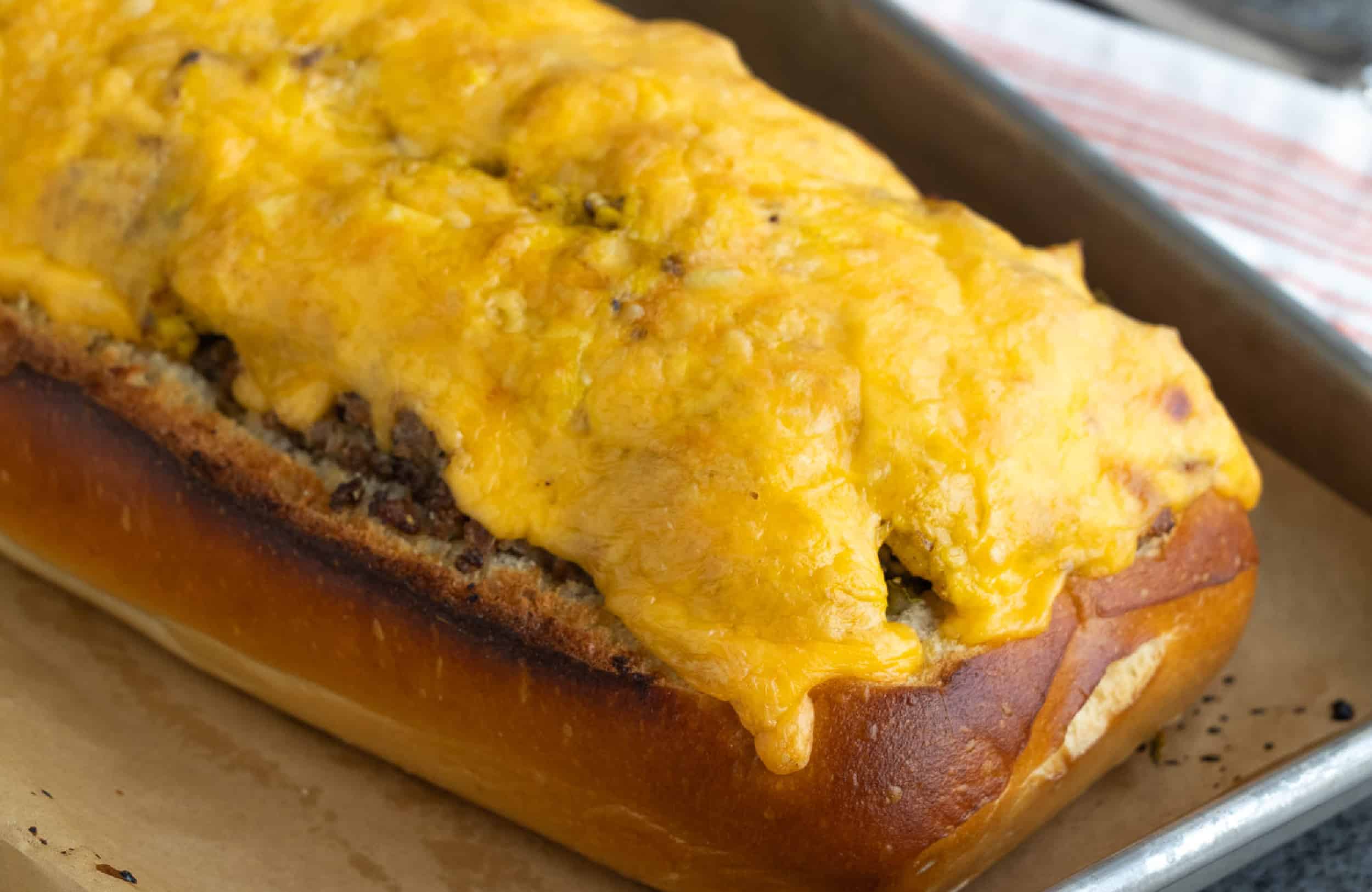 A cheesy grilled sandwich on a baking sheet.