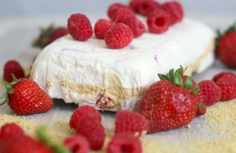 A slice of mousse with raspberries and powdered sugar.