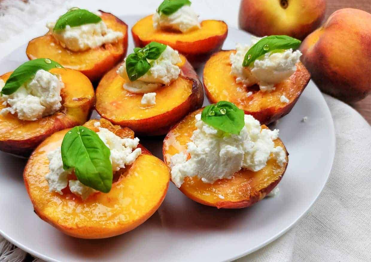 A plate of peaches stuffed with goat cheese and basil.