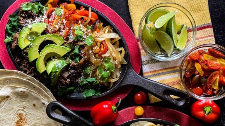 A skillet with Tender Shaved Beef Fajitas.