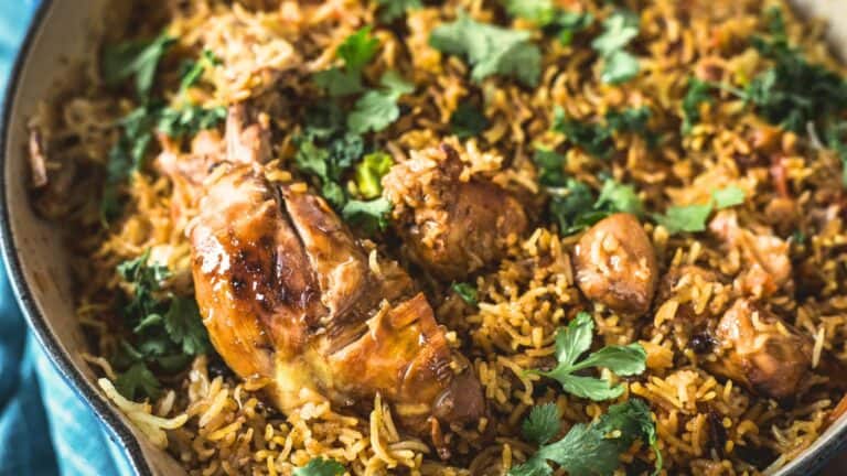 A pan of chicken biryani garnished with fresh cilantro.