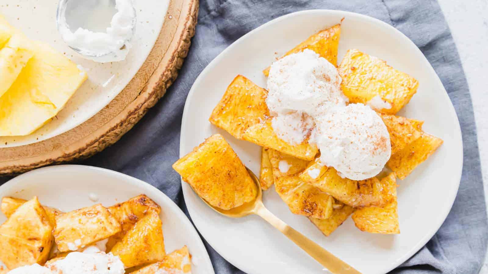 Air fryer pineapple on plates with vanilla ice cream.