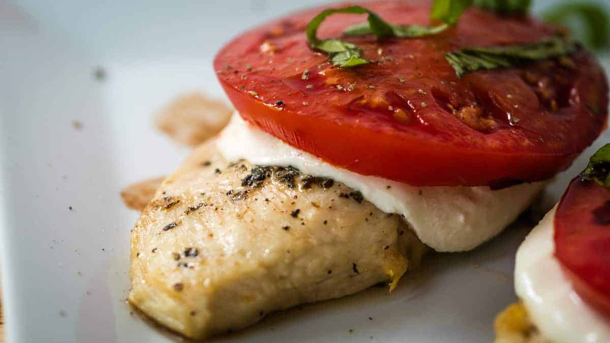 Chicken breast topped with melted mozzarella cheese and tomato.