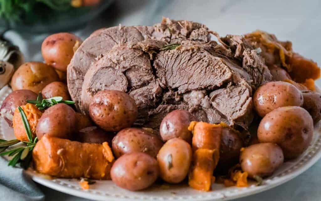 A platter of pot roast with carrots and potatoes.