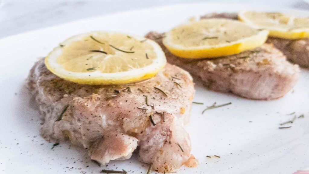 Lemon Pepper Pork Chops with rosemary garnish.