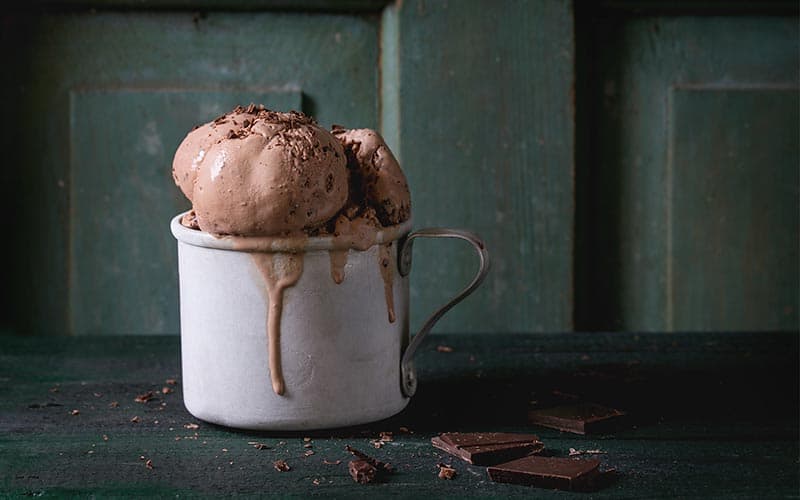 Chocolate Mason Jar Ice Cream overflowing a tin mug and dripping over.