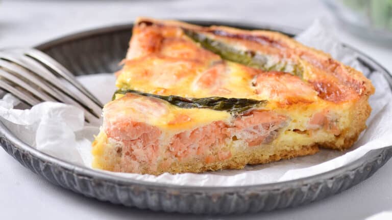 Salmon quiche on a plate with a fork.