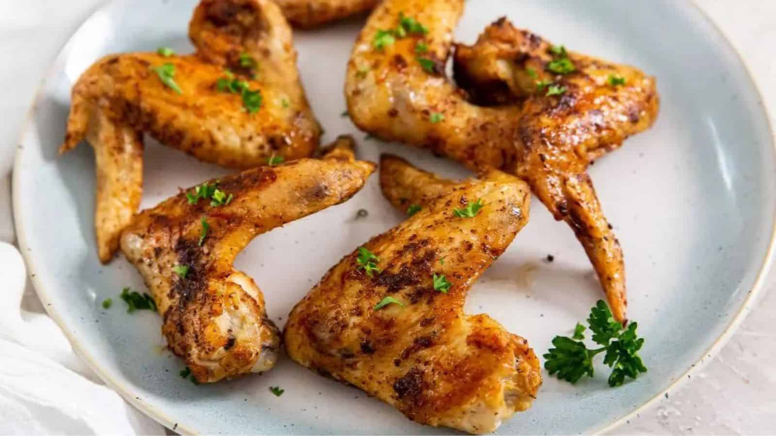 Air Fryer Whole Chicken Wings on a light blue plate with parsley.