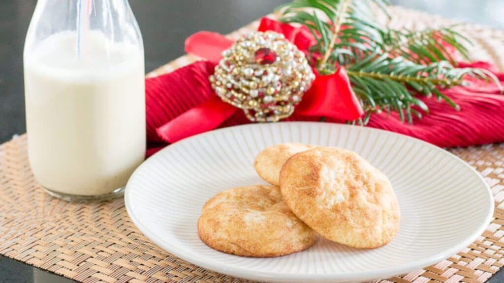 A plate of cookies paired with a glass of milk, presented with festive holiday decor.