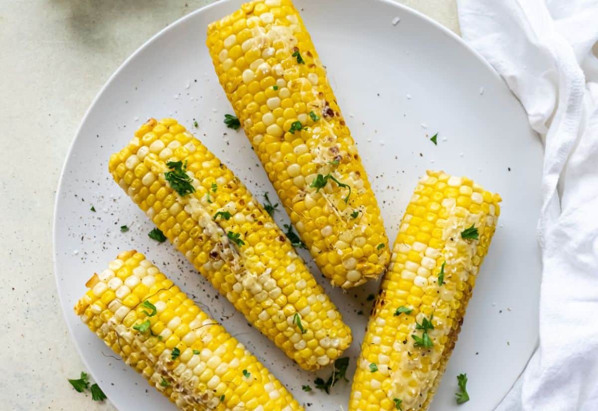 4 corn on the cob topped with butter and parlesy that were cooked on the Blackstone griddle.
