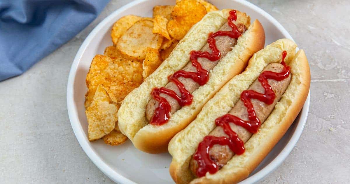 Easy Air Fryer Trader Joe's Sweet Apple Chicken Sausage in a bun with ketchup.