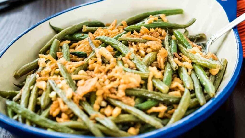A bowl of green beans with slivered almonds.
