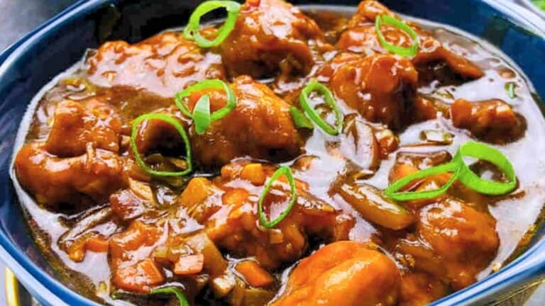 A bowl of Gobi Manchurian garnished with sliced green onions.