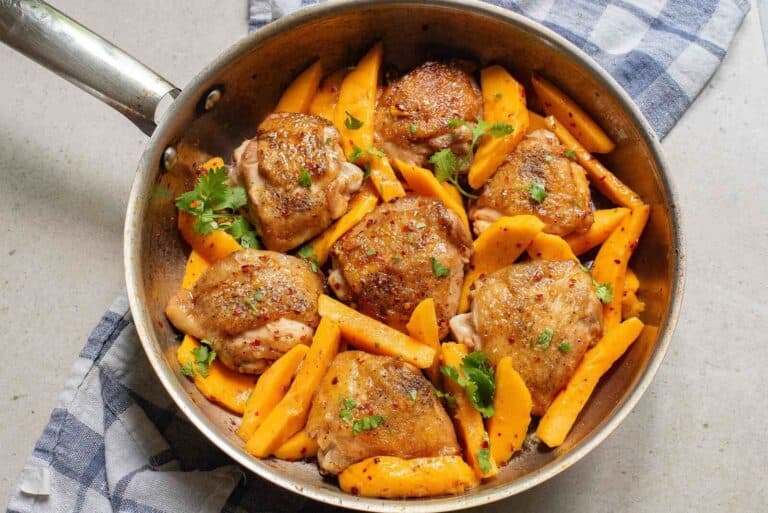 Chicken and mango slices in a pan.