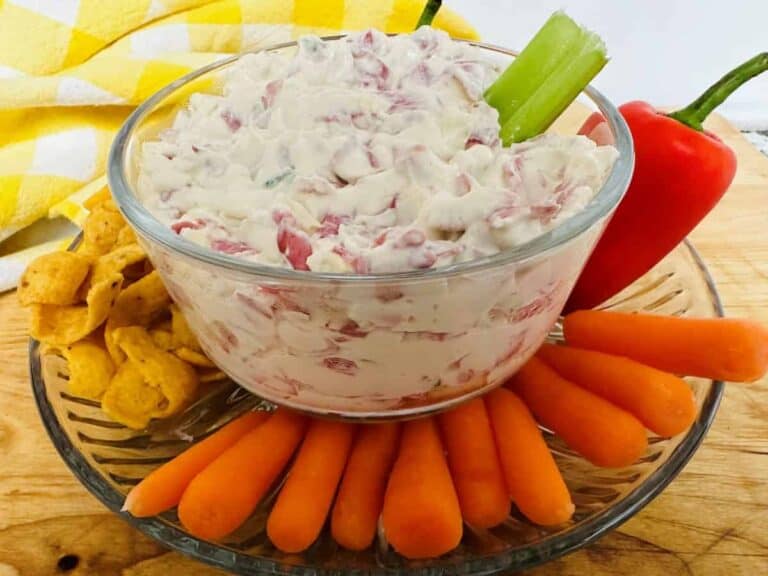 Bowl of dip surrounded by assorted vegetables and chips.