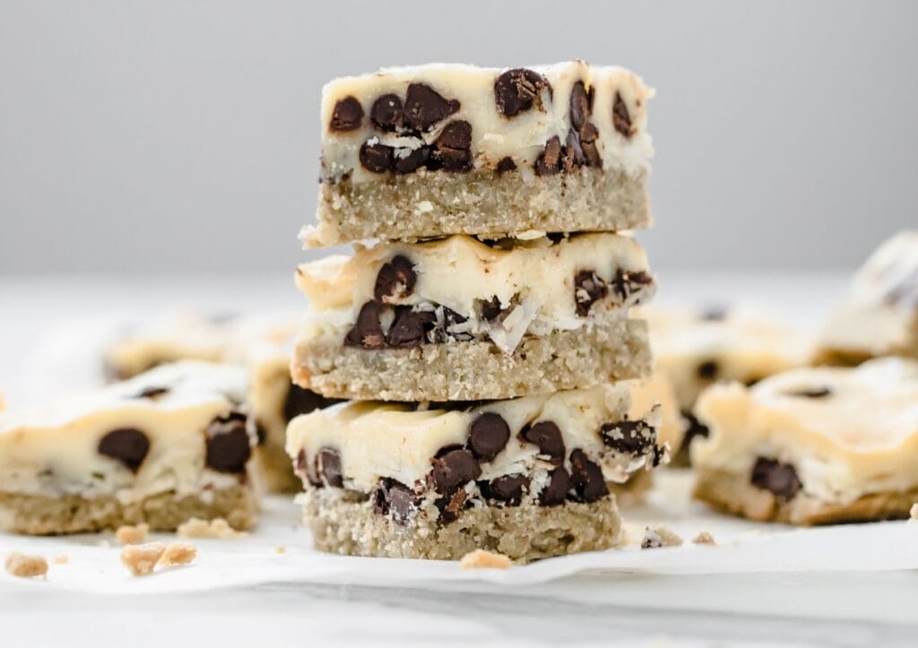 A stack of magic bars with a creamy filling on a white surface.