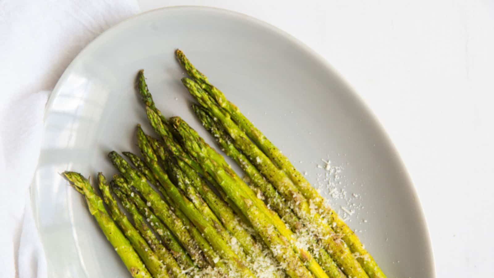 Roasted Garlic Parmesan Asparagus on foil with parmesan, salt, and pepper.