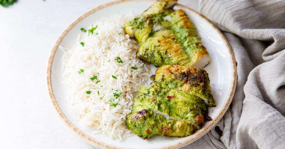 Trader Joe's Pesto Chicken in the Air Fryer on a white plate with white rice and parsley.