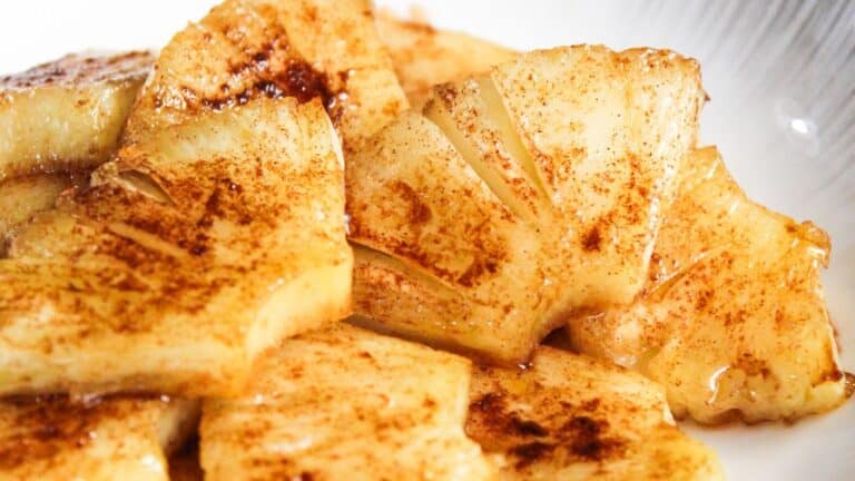 Sliced pinieapples sprinkled with cinnamon on a plate.