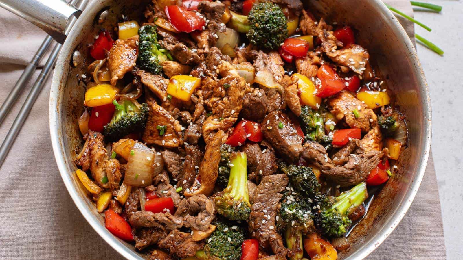 Chicken and steak stir fry with vegetables and sauce.
