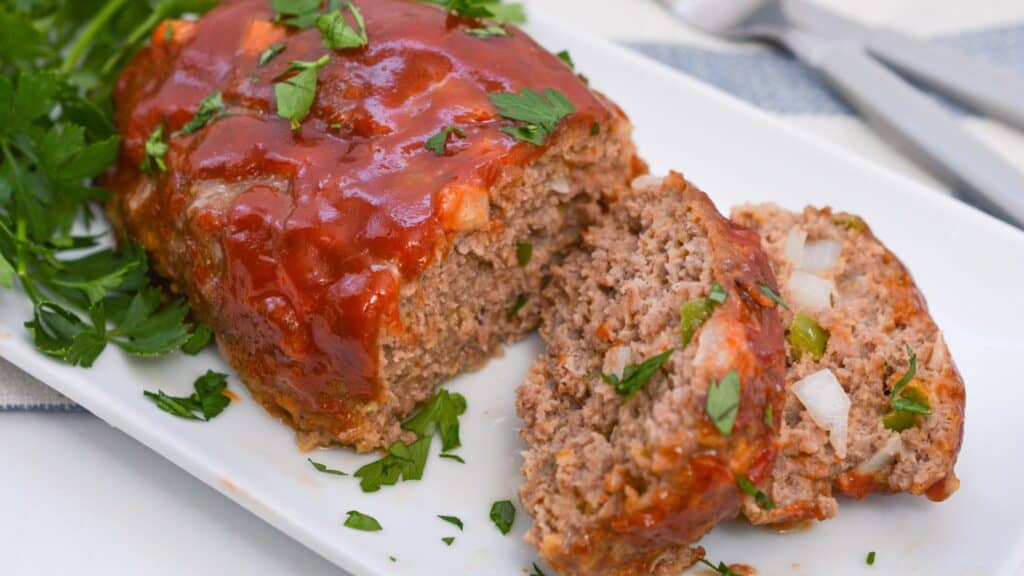 Meatloaf on a white plate with a fork.