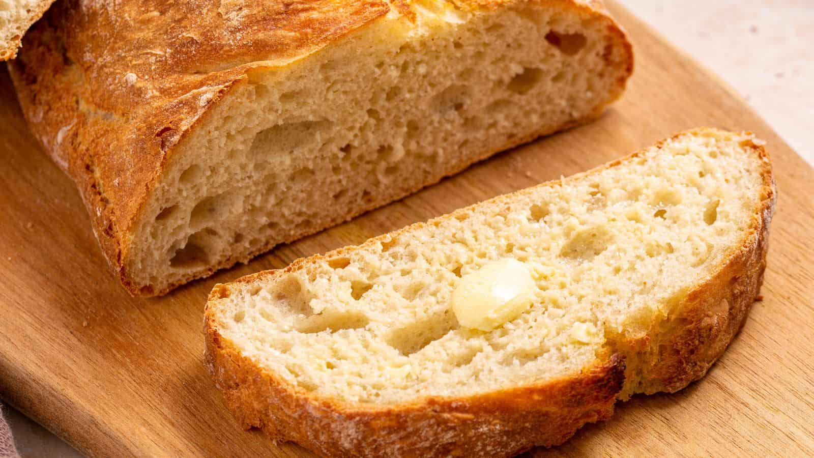 Italian artisan bread sliced on cutting board.