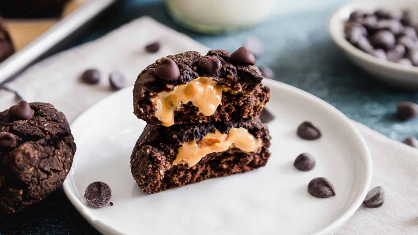 Peanut butter stuffed chocolate cookies stacked on a white plate.