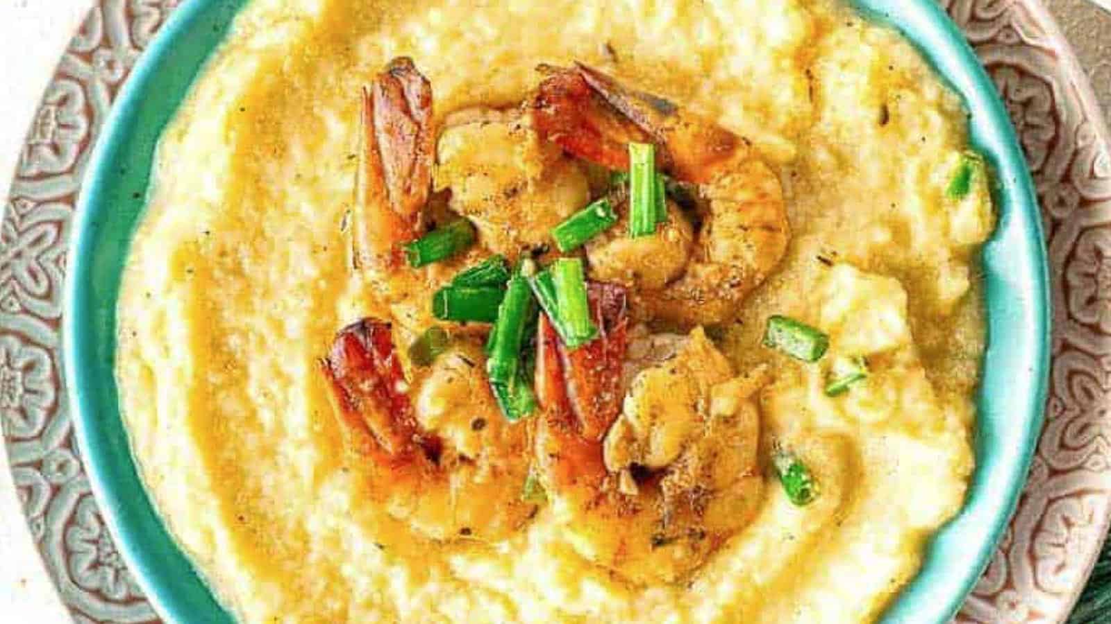 An overhead shot of a bowl of grits with shrimp on top.