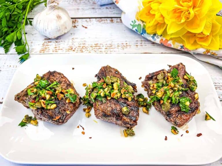 Three Ninja Woodfire Grill Mediterranean Lamb Chops topped with gremolata on a white plate.