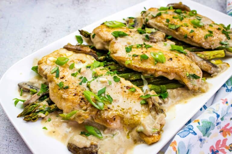 A plate of creamy keto chicken marsala with chopped green onions.