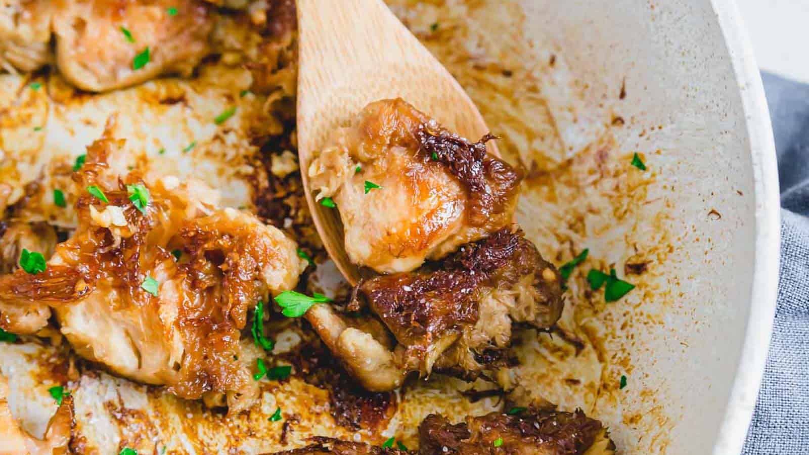 Lion's mane mushrooms in a pan with a wooden spoon.