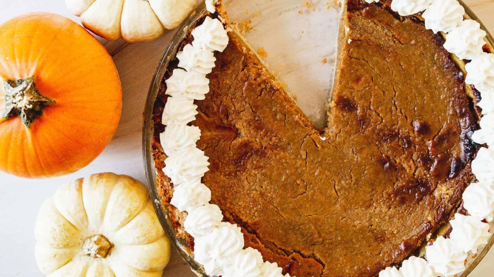 Overhead view of pumpkin pecan pie with a slice missing.