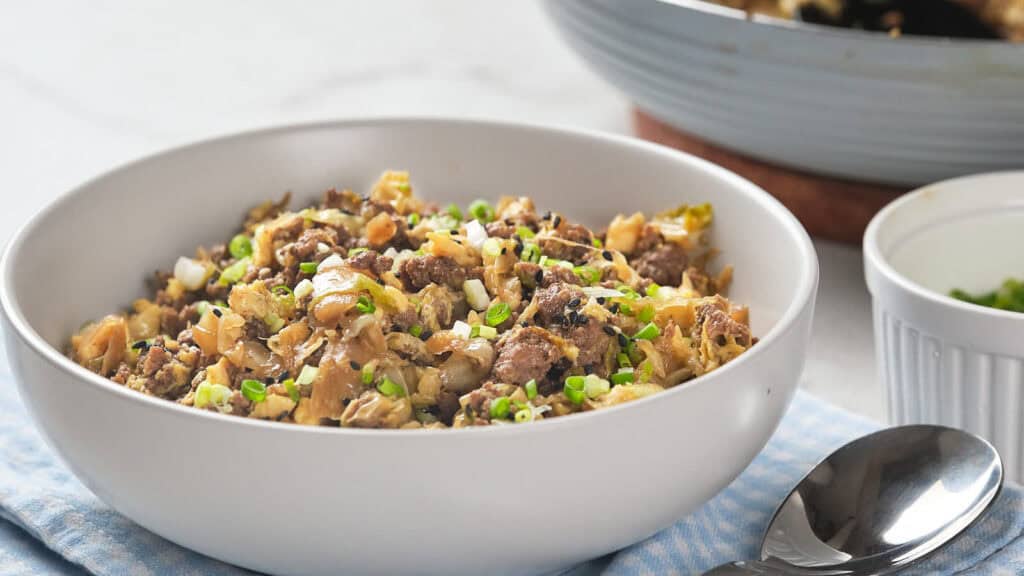 A white bowl filled with egg roll in a bowl.