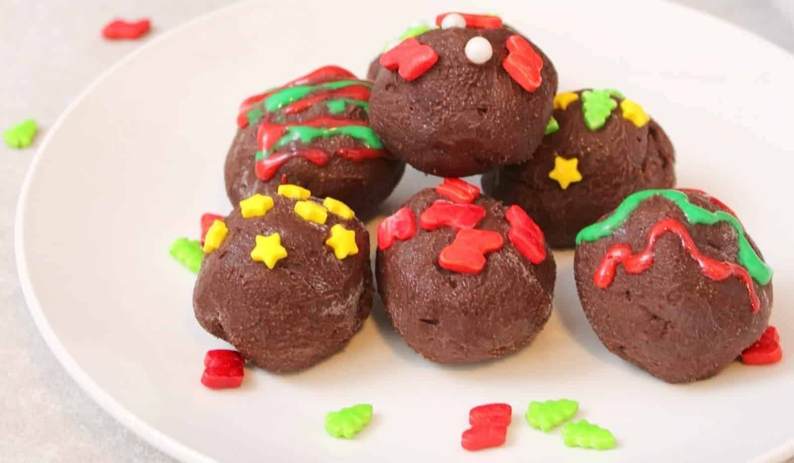 Chocolate Christmas truffles on a white plate.