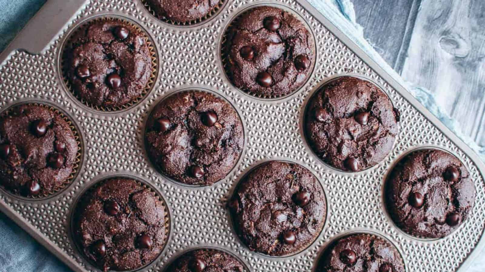 A baking tray with 12 chocolate zucchini muffins.