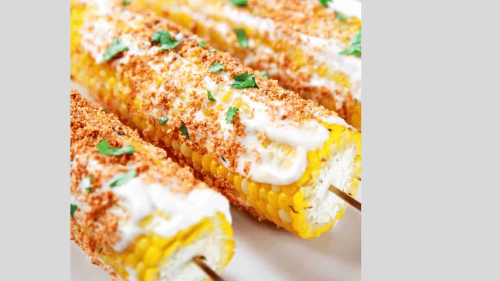 Corn on the cob topped with mexican spices and cilantro.