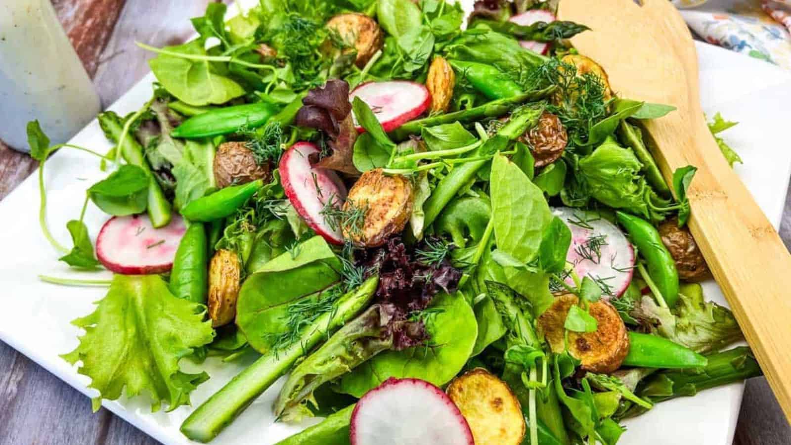 Spring salad with asparagus and potatoes on a white plate.