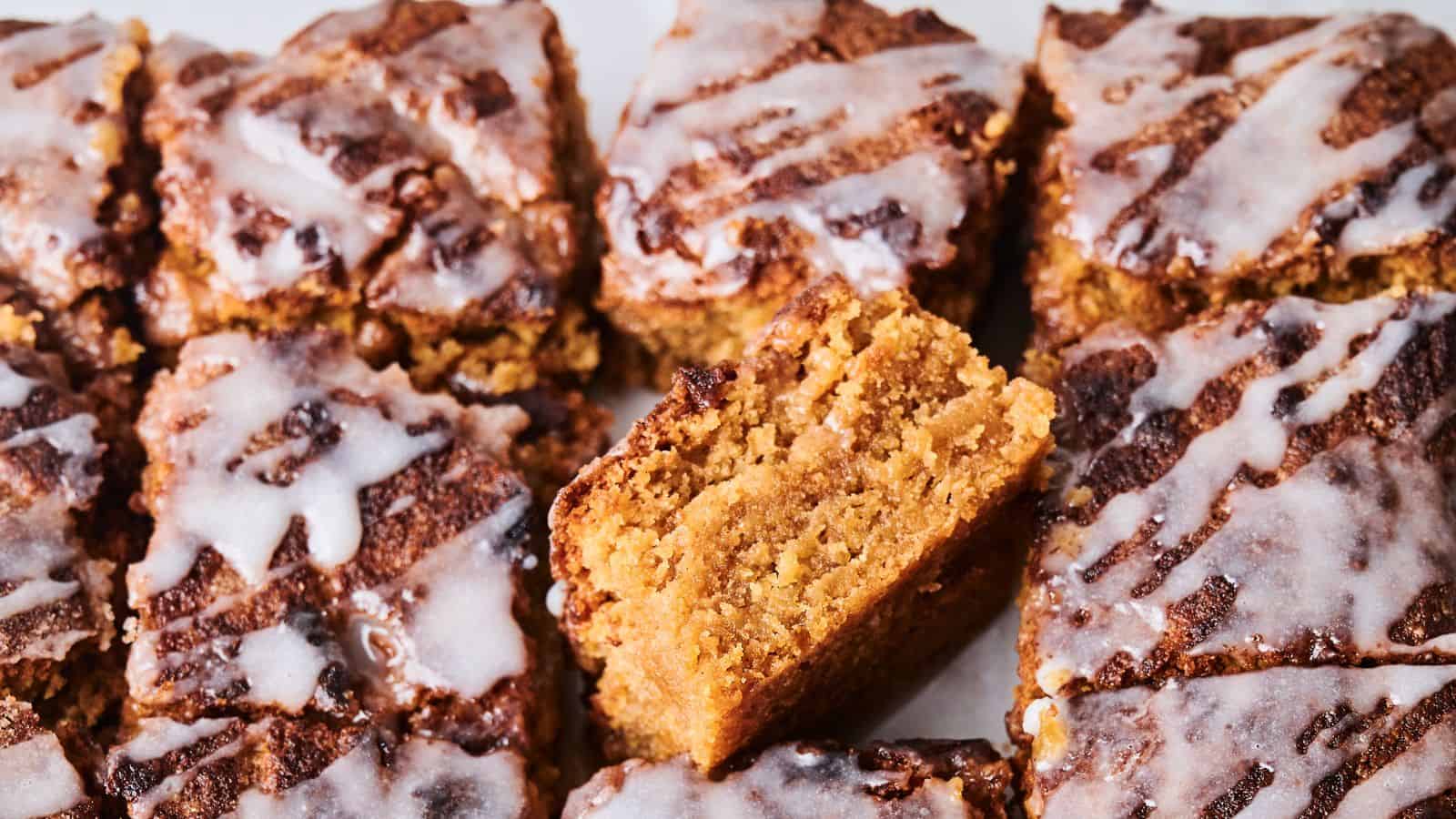 Close-up of sliced crumbly cakes topped with white icing. One piece is positioned vertically to show its texture.